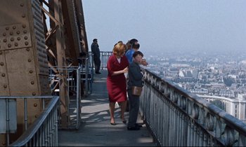 Movie still from “Bon Voyage!” (1962), directed by James Neilson – A group of people standing on top of a metal fence; Wide shot, High angle