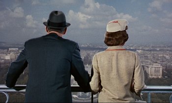 Movie still from “Bon Voyage!” (1962), directed by James Neilson – A man and a woman looking out over a city; Medium shot, Low angle
