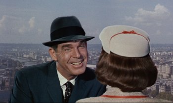 Movie still from “Bon Voyage!” (1962), directed by James Neilson – An older man wearing a hat and smiling at a young woman; Close Up shot, Over the shoulder angle
