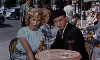Movie still from “Bon Voyage!” (1962), directed by James Neilson – A man and a woman sitting at a table with wine glasses; Medium shot, High angle