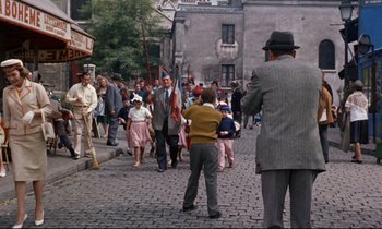 Movie still from “Bon Voyage!” (1962), directed by James Neilson – A crowd of people walking down a street; Wide shot, High angle