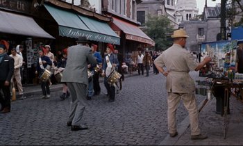 Movie still from “Bon Voyage!” (1962), directed by James Neilson – A crowd of people walking down a street; Wide shot, High angle