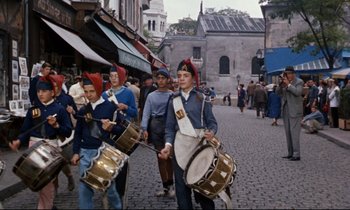 Movie still from “Bon Voyage!” (1962), directed by James Neilson – A group of young men marching down a street; Wide shot, High angle