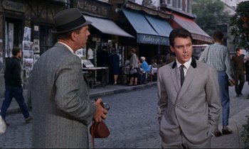 Movie still from “Bon Voyage!” (1962), directed by James Neilson – A man in a suit and tie talking to another man in a suit and tie; Medium shot, Over the shoulder angle