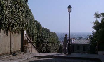 Movie still from “Bon Voyage!” (1962), directed by James Neilson – A man standing next to a street light on the side of the road; Extreme Wide shot, High angle
