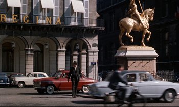 Movie still from “Bon Voyage!” (1962), directed by James Neilson – A man standing on the side of the road next to a car; Extreme Wide shot, Low angle