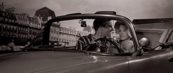 Movie still from “Bonjour Tristesse” (1958), directed by Otto Preminger – A man driving a car with another man in the back seat; Close Up shot, High angle