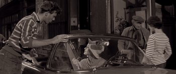 Movie still from “Bonjour Tristesse” (1958), directed by Otto Preminger – A woman is sitting in the back seat of a car; Medium shot, Over the shoulder angle
