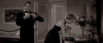 Movie still from “Bonjour Tristesse” (1958), directed by Otto Preminger – A man and a woman in a black dress in front of a mirror; Medium shot, Low angle