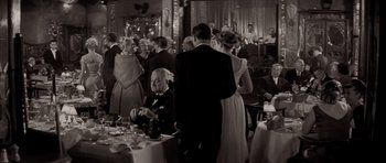 Movie still from “Bonjour Tristesse” (1958), directed by Otto Preminger – A black and white photo of people at a formal event; Wide shot, Over the shoulder angle