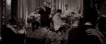 Movie still from “Bonjour Tristesse” (1958), directed by Otto Preminger – A black and white photo of a group of men playing instruments; Medium shot, Low angle