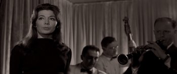Movie still from “Bonjour Tristesse” (1958), directed by Otto Preminger – A woman standing next to a man holding a trumpet; Close Up shot, Low angle