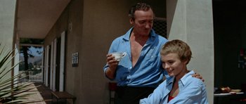 Movie still from “Bonjour Tristesse” (1958), directed by Otto Preminger – A man standing next to a young boy holding a cup; Medium shot, Low angle