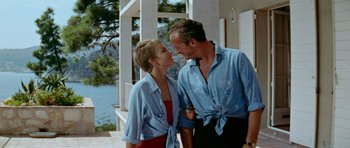 Movie still from “Bonjour Tristesse” (1958), directed by Otto Preminger – A man and a woman standing next to each other on a porch; Medium shot, Low angle