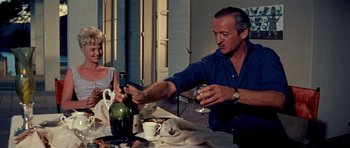 Movie still from “Bonjour Tristesse” (1958), directed by Otto Preminger – An older man and a young woman at an outdoor dining table; Medium shot, Low angle
