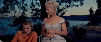 Movie still from “Bonjour Tristesse” (1958), directed by Otto Preminger – A woman in a dress is holding a cigarette in her hand; Medium shot, Low angle
