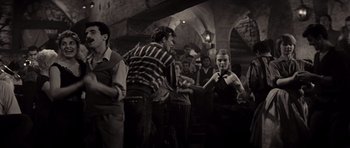 Movie still from “Bonjour Tristesse” (1958), directed by Otto Preminger – A group of people standing around in a room; Wide shot, High angle