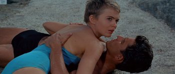Movie still from “Bonjour Tristesse” (1958), directed by Otto Preminger – A man and a woman are wrestling on the beach; Close Up shot, High angle