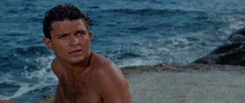 Movie still from “Bonjour Tristesse” (1958), directed by Otto Preminger – A man sitting on the beach in front of the ocean; Close Up shot, Over the shoulder angle