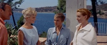 Movie still from “Bonjour Tristesse” (1958), directed by Otto Preminger – A group of people standing next to each other near a body of water; Medium shot, Over the shoulder angle