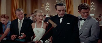 Movie still from “Bonjour Tristesse” (1958), directed by Otto Preminger – A man and a woman in formal wear holding a baseball bat; Medium shot, Low angle