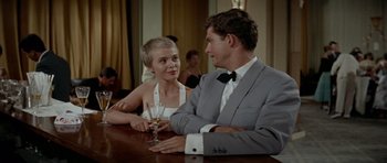 Movie still from “Bonjour Tristesse” (1958), directed by Otto Preminger – A man and a woman sitting at a table with a glass of wine; Medium shot, Over the shoulder angle