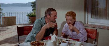 Movie still from “Bonjour Tristesse” (1958), directed by Otto Preminger – A man and a woman sitting at a table eating food; Medium shot, High angle