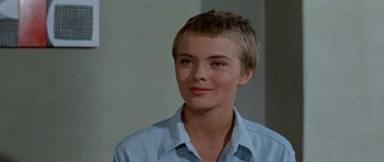 Movie still from “Bonjour Tristesse” (1958), directed by Otto Preminger – A woman with short blonde hair wearing a blue shirt; Close Up shot, Over the shoulder angle