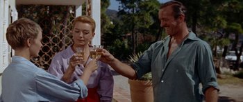 Movie still from “Bonjour Tristesse” (1958), directed by Otto Preminger – A group of people standing next to each other holding wine glasses; Medium shot, Low angle