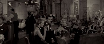 Movie still from “Bonjour Tristesse” (1958), directed by Otto Preminger – A group of people sitting around a table; Medium shot, High angle