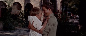 Movie still from “Bonjour Tristesse” (1958), directed by Otto Preminger – A man and a boy are laughing together outside; Medium shot, Low angle