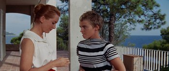 Movie still from “Bonjour Tristesse” (1958), directed by Otto Preminger – A young boy smoking a cigarette while a woman looks on; Medium shot, Low angle
