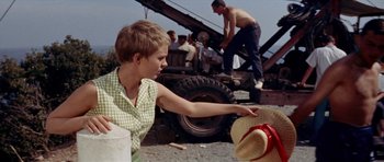 Movie still from “Bonjour Tristesse” (1958), directed by Otto Preminger – A young boy wearing a cowboy hat points to a tire on the ground; Medium shot, Over the shoulder angle