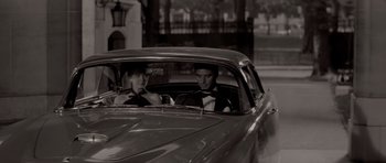 Movie still from “Bonjour Tristesse” (1958), directed by Otto Preminger – A couple of men sitting in the back seat of a car; Medium shot, Low angle