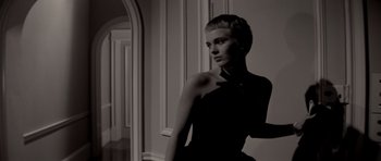 A woman standing in front of a mirror in front of a wall