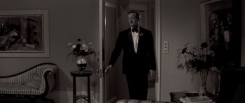 Movie still from “Bonjour Tristesse” (1958), directed by Otto Preminger – A man in a tuxedo standing in front of a door; Medium shot, Over the shoulder angle