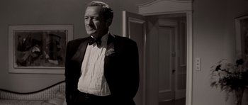 Movie still from “Bonjour Tristesse” (1958), directed by Otto Preminger – An older man wearing a tuxedo and a bow tie; Medium shot, Over the shoulder angle
