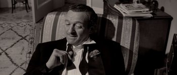 Movie still from “Bonjour Tristesse” (1958), directed by Otto Preminger – A black and white photo of a man adjusting his tie; Close Up shot, High angle