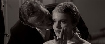 Movie still from “Bonjour Tristesse” (1958), directed by Otto Preminger – An older man kissing a younger woman's cheek; Close Up shot, Over the shoulder angle