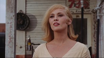Movie still from “Bonnie and Clyde” (1967), directed by Arthur Penn – A woman with blonde hair is standing in front of a building; Close Up shot, Low angle