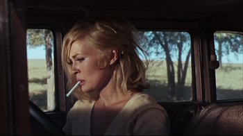 Movie still from “Bonnie and Clyde” (1967), directed by Arthur Penn – A woman smoking a cigarette while sitting in a car; Close Up shot, Low angle