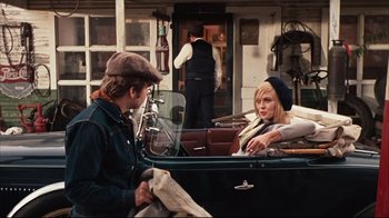 Movie still from “Bonnie and Clyde” (1967), directed by Arthur Penn – A man and a woman sitting in the back of an old car; Medium shot, Over the shoulder angle
