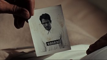 Movie still from “Bonnie and Clyde” (1967), directed by Arthur Penn – An old photo of a man in a white shirt; Extreme Close Up shot, High angle
