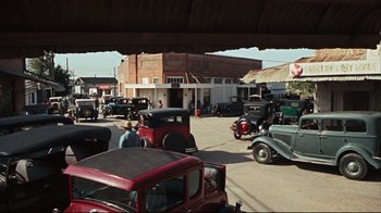 Movie still from “Bonnie and Clyde” (1967), directed by Arthur Penn – An old time car show with antique cars parked in the middle of the street; Extreme Wide shot, High angle