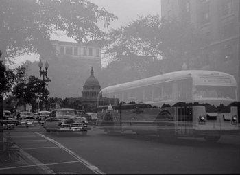 Movie still from “Born Yesterday” (1950), directed by George Cukor – A black and white photo of a city street with cars and a bus; Wide shot, Low angle