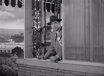 Movie still from “Born Yesterday” (1950), directed by George Cukor – An old photo of a man looking out of a window; Medium shot, Low angle