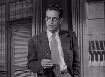 Movie still from “Born Yesterday” (1950), directed by George Cukor – A black and white photo of a man holding a cell phone; Medium shot, Low angle
