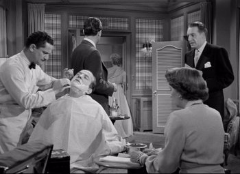 Movie still from “Born Yesterday” (1950), directed by George Cukor – A man getting a haircut in a barber shop; Medium shot, Over the shoulder angle