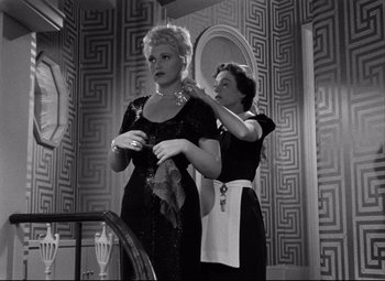 Movie still from “Born Yesterday” (1950), directed by George Cukor – Two women in a room with a mirror; Medium shot, Low angle