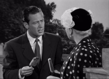 Movie still from “Born Yesterday” (1950), directed by George Cukor – A man in a business suit talking to an older woman; Close Up shot, Over the shoulder angle